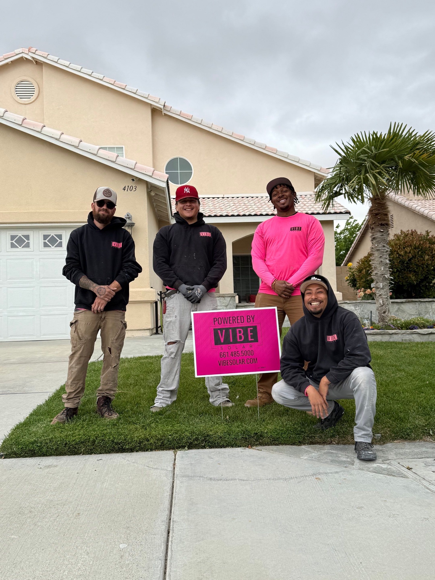 Vibe Solar crew with a Powered by Vibe Solar yard sign in front of a completed install